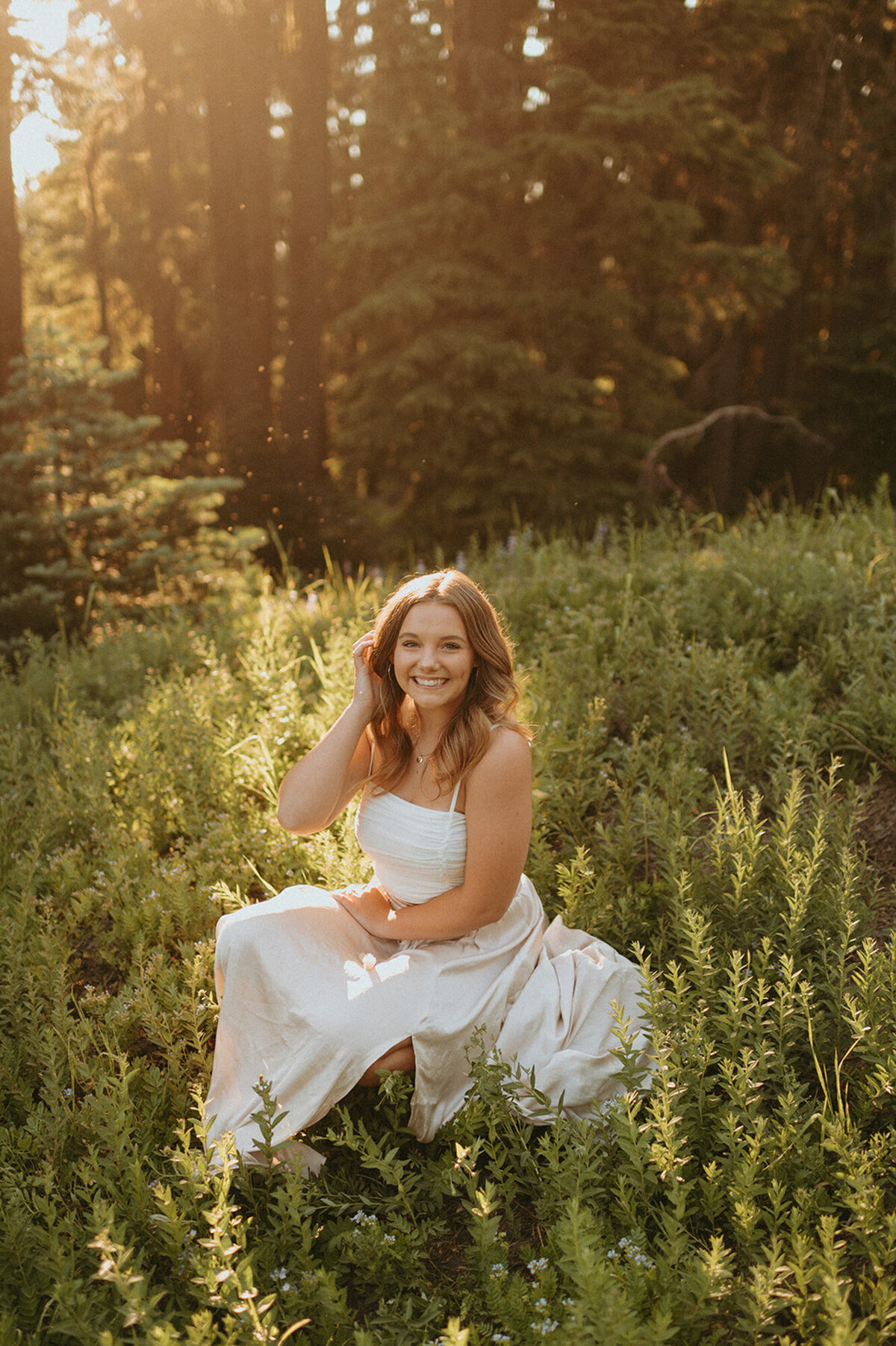 girl in white dress sitting in the forest