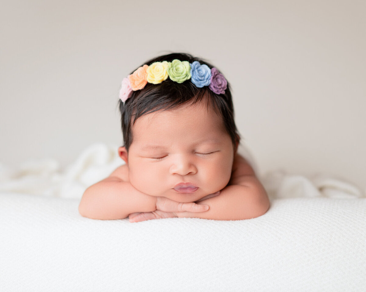Close-up of newborn baby girl with rainbow flower headband – Houston photographer