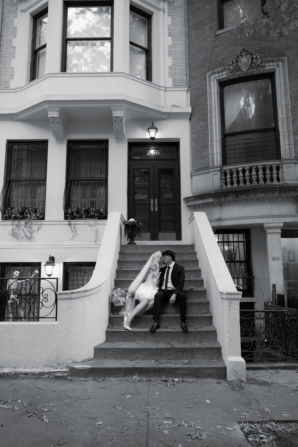 Elopement couple sitting on the steps of a brownstone in New York City.