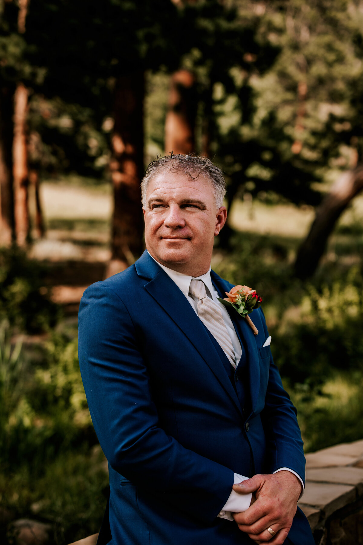 Groom waiting for his wife in a navy blue suit in Estes Park, Colorado