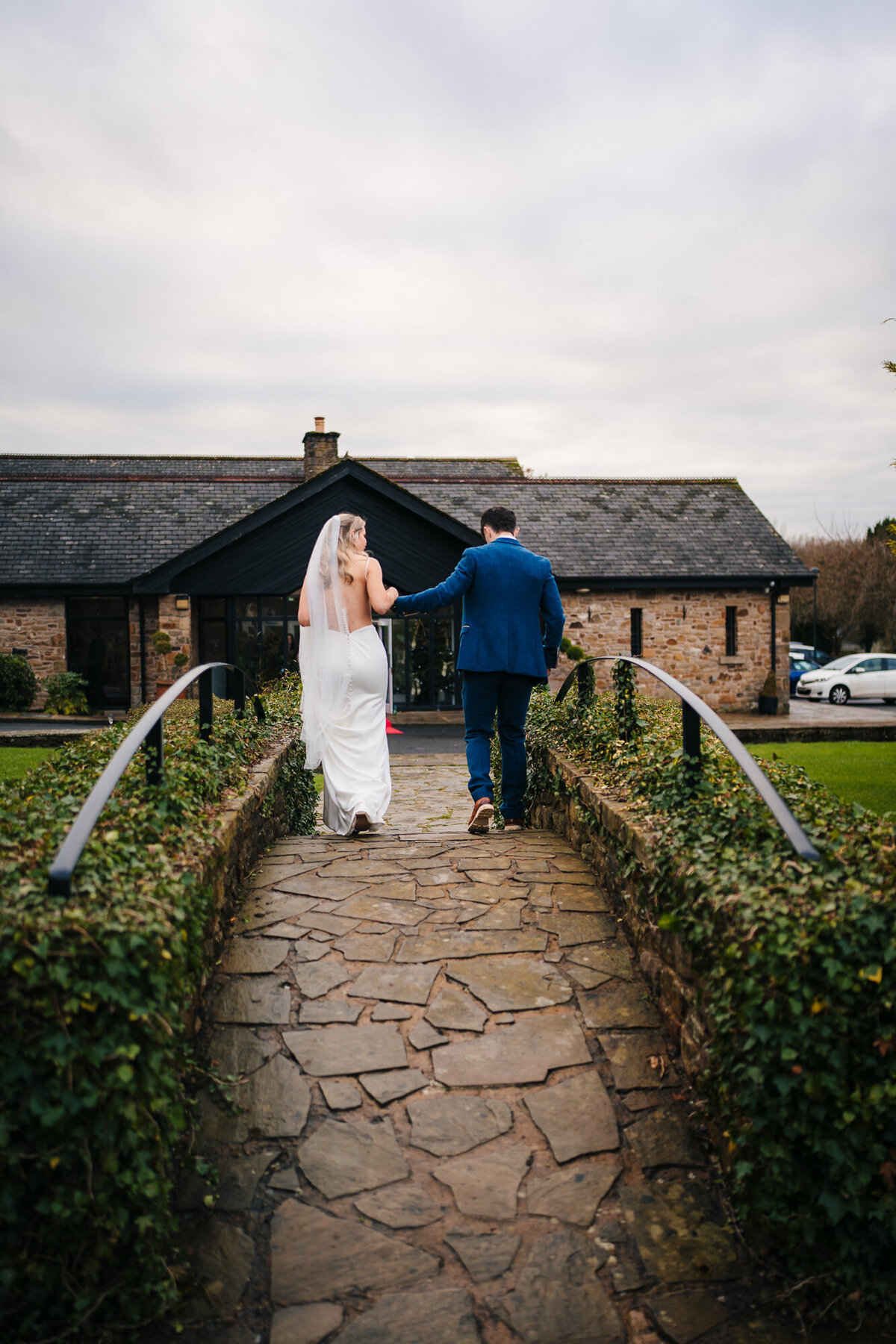 Bride and groom walking over the bridge at Mytton Foild Hotel taken by  Wedding videographer and photographer Anthony Hosreman