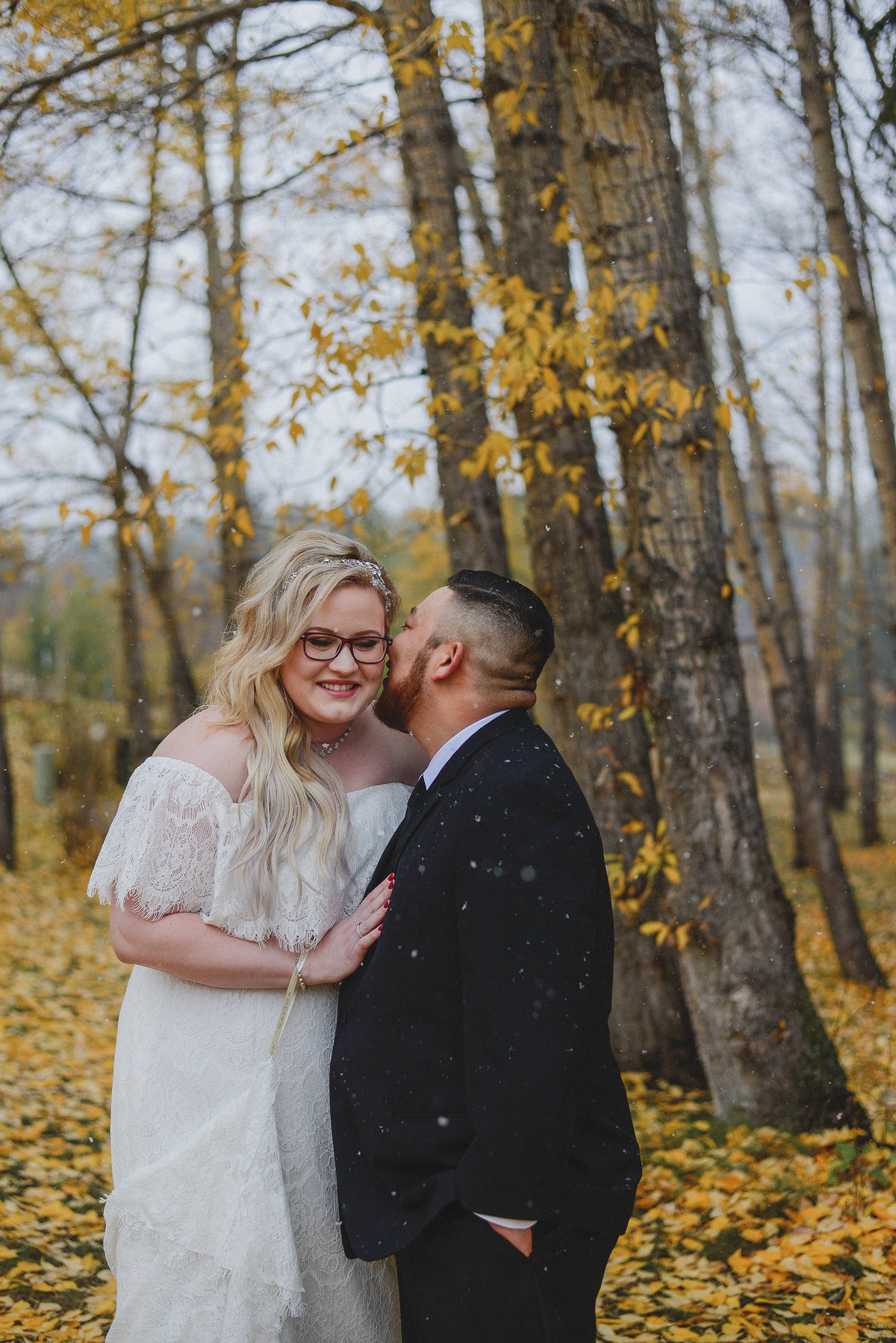 bride and groom kissing in fall forest