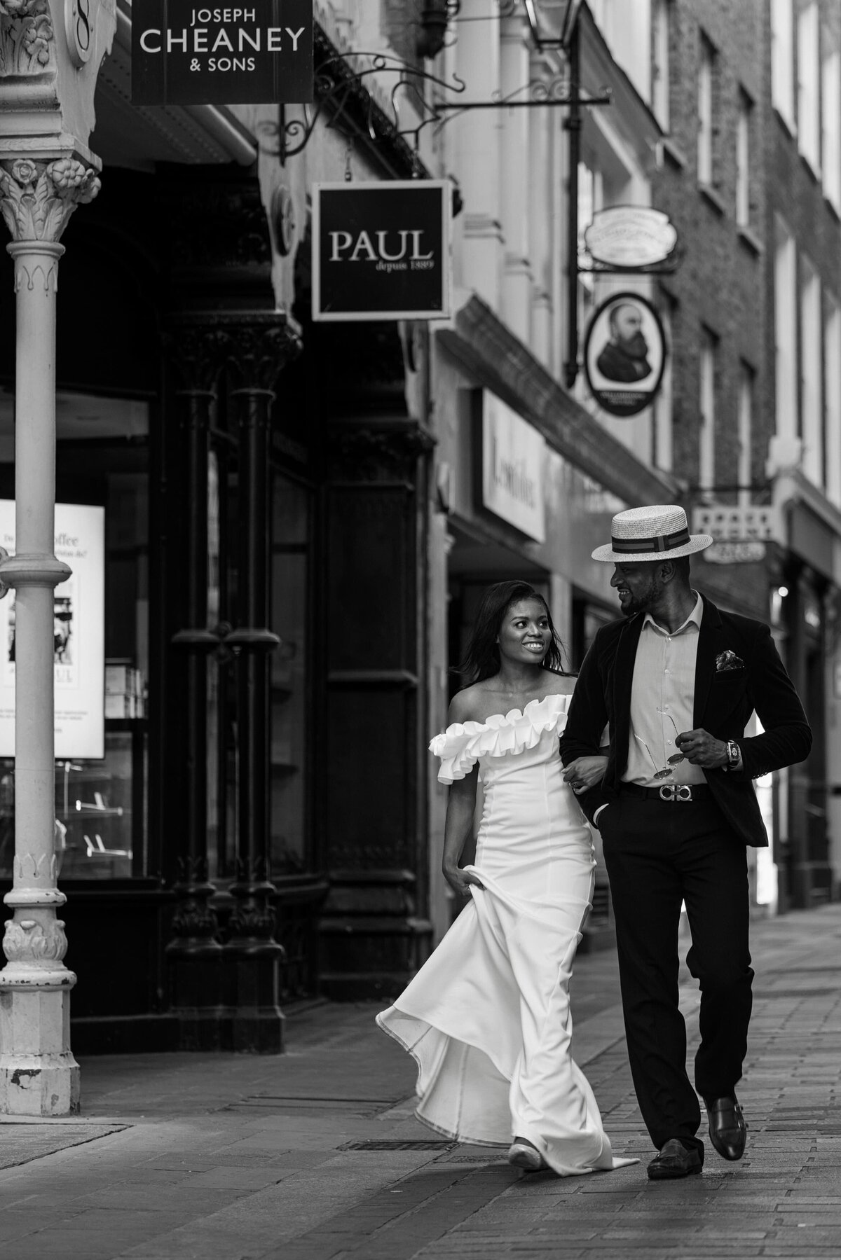 candid photo of a happy couple holding hands walking in the old street of London  during their wedding photography