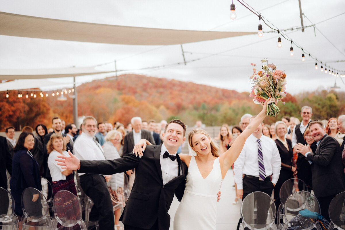 Bride and groom celebrating as they walk down the aisle, taken by Asheville Wedding Photographer Simon Anthony Photography