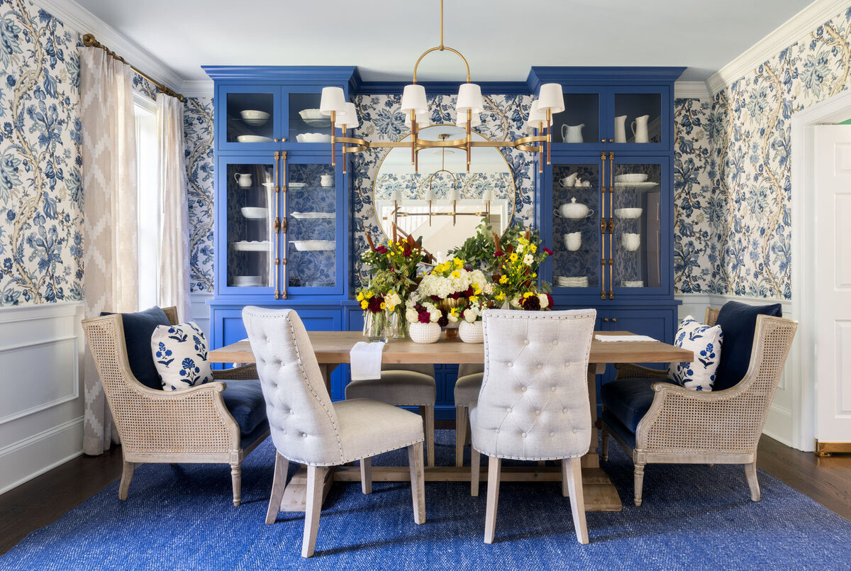 blue and white floral patterned dining room with blue china cabinets in the back