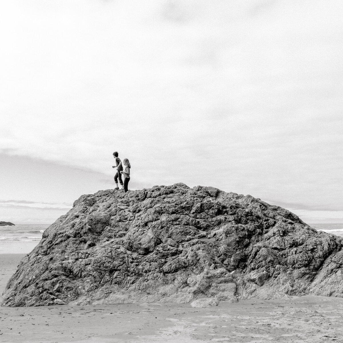 children climbing rocks on the beach in Bandon