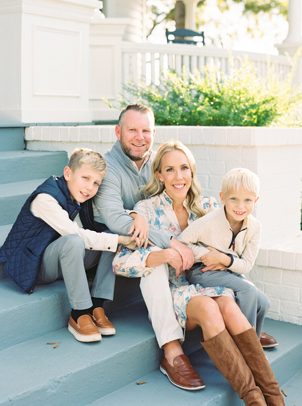 Family sits on the front porch of The Carolina Manor in Franklinton NC for a portrait. Image by Raleigh maternity photographer A.J. Dunlap Photography.