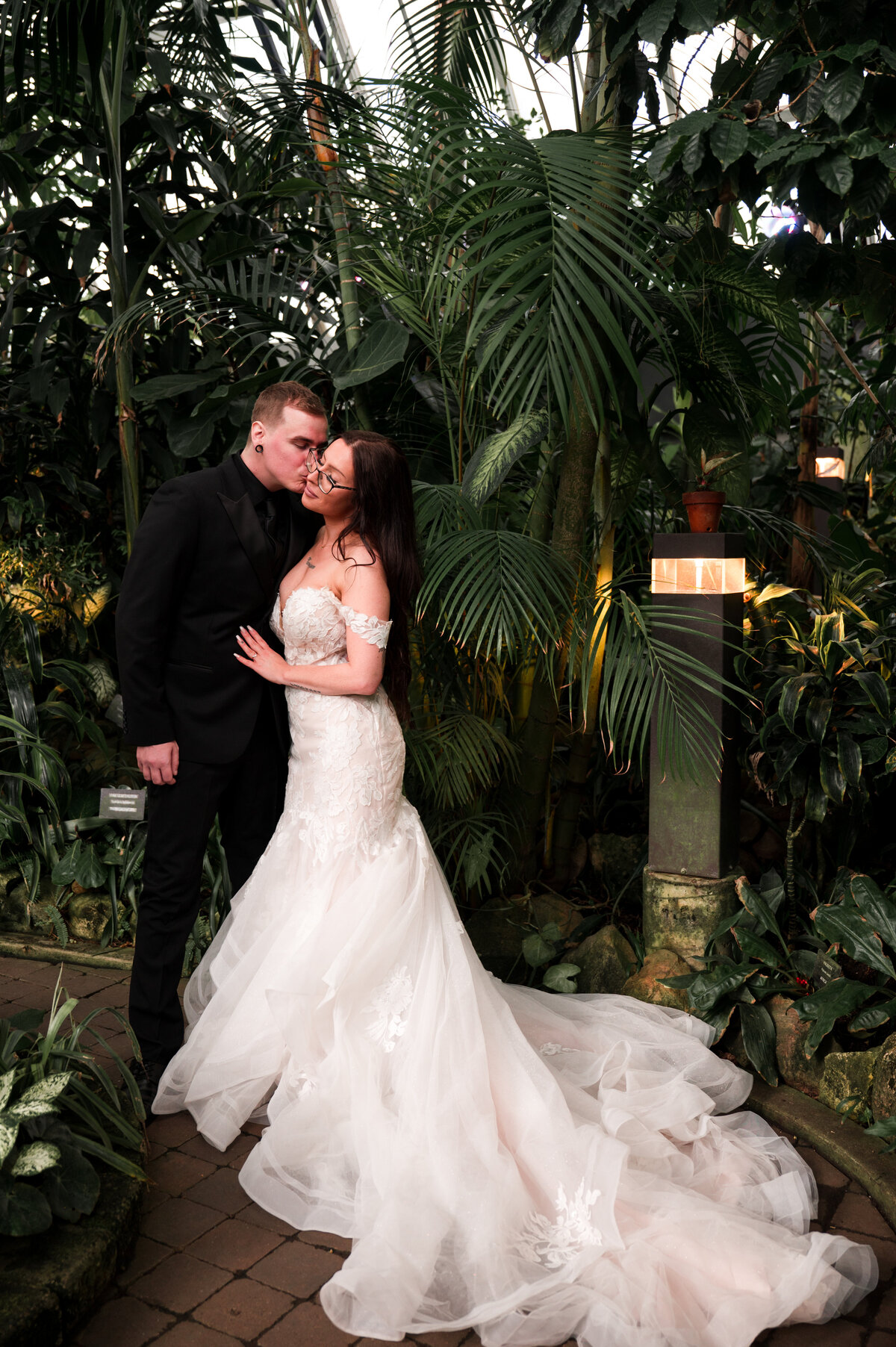 groom kisses his bride on the cheek at tropical destination wedding
