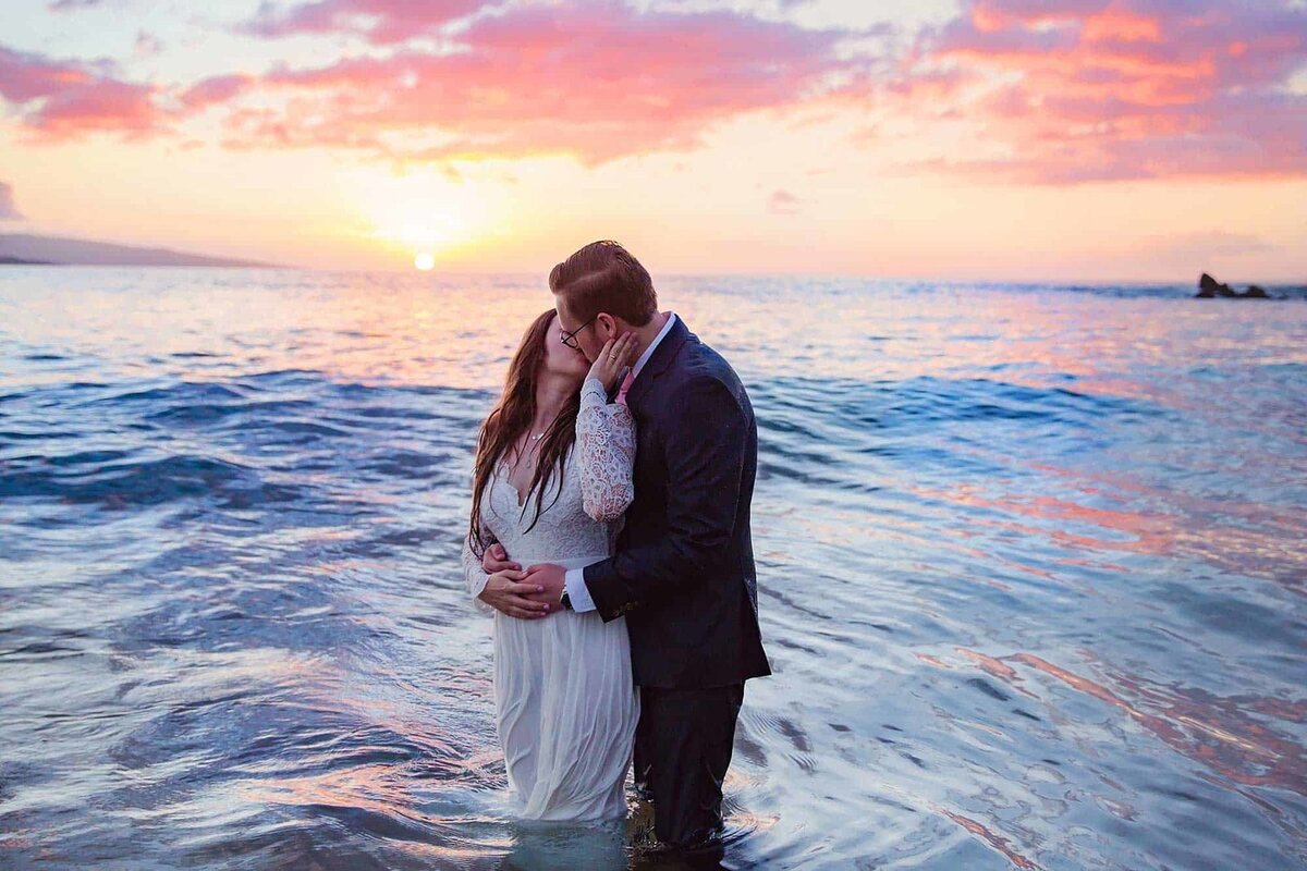 Love + Water Photography capture a newly engaged couples portraits in the ocean in Wailea just after sunset