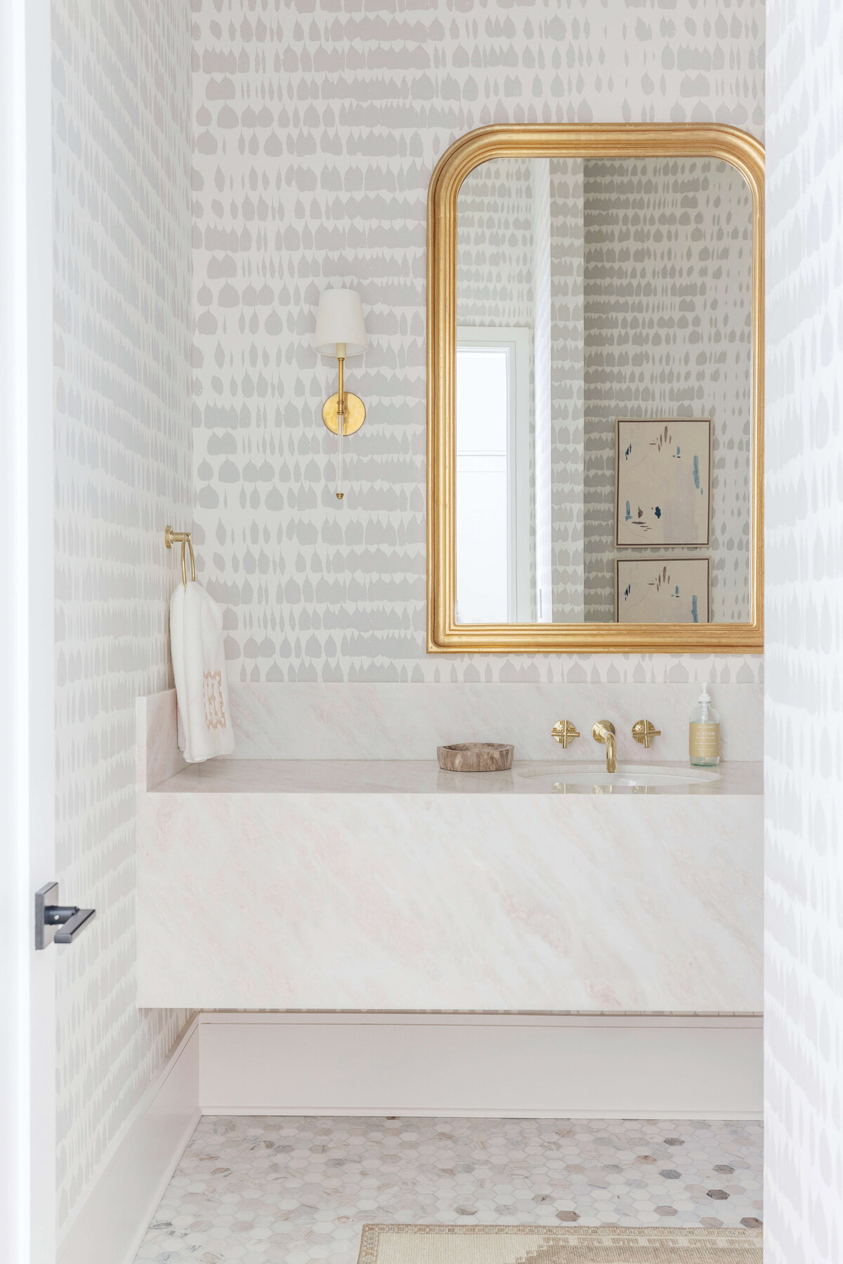 oyster creek studios hughes white marble vanity and gray wallpaper in bathroom