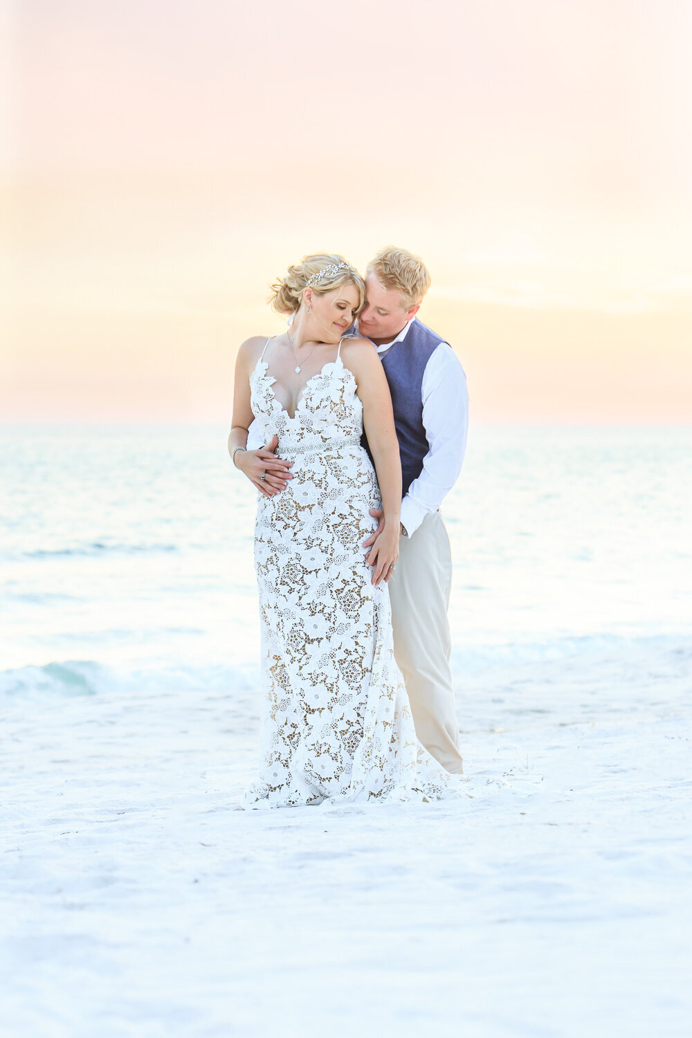 A bride and groom take a wedding portrait on the beach at carillon