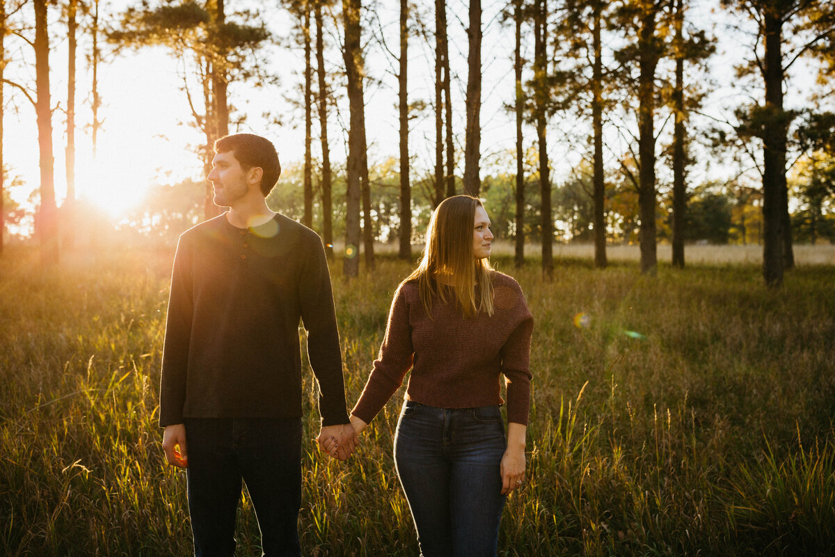 engaged-couple-in-field-at-sunset
