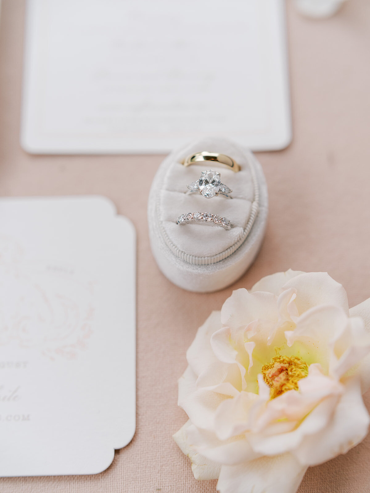 Engagement ring and wedding bands in a velvet ring box with soft blush floral accent, photographed at The Waynesville Inn wedding in Waynesville, NC.