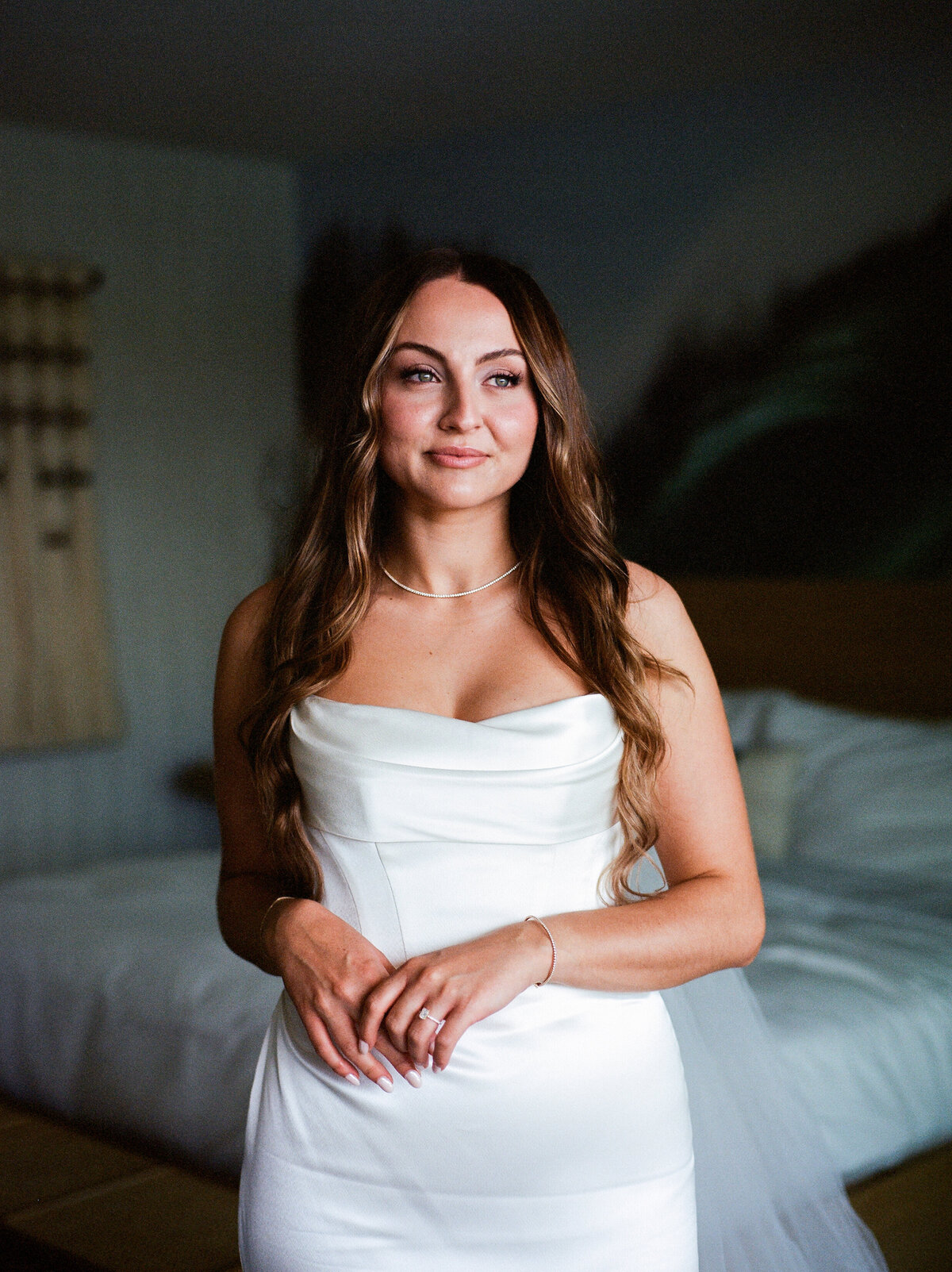 Elegant bridal portrait by the window, photographed on film with soft, nostalgic tones.