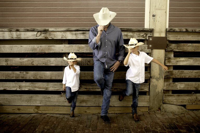 Laughter fills the air as the family enjoys a playful, carefree moment in their outdoor photoshoot at the stockyards in fort worth