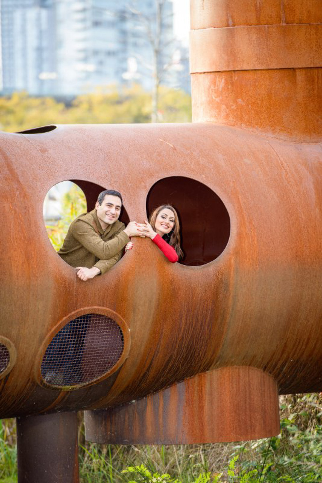 Engaged couple pposing inside metal architecture