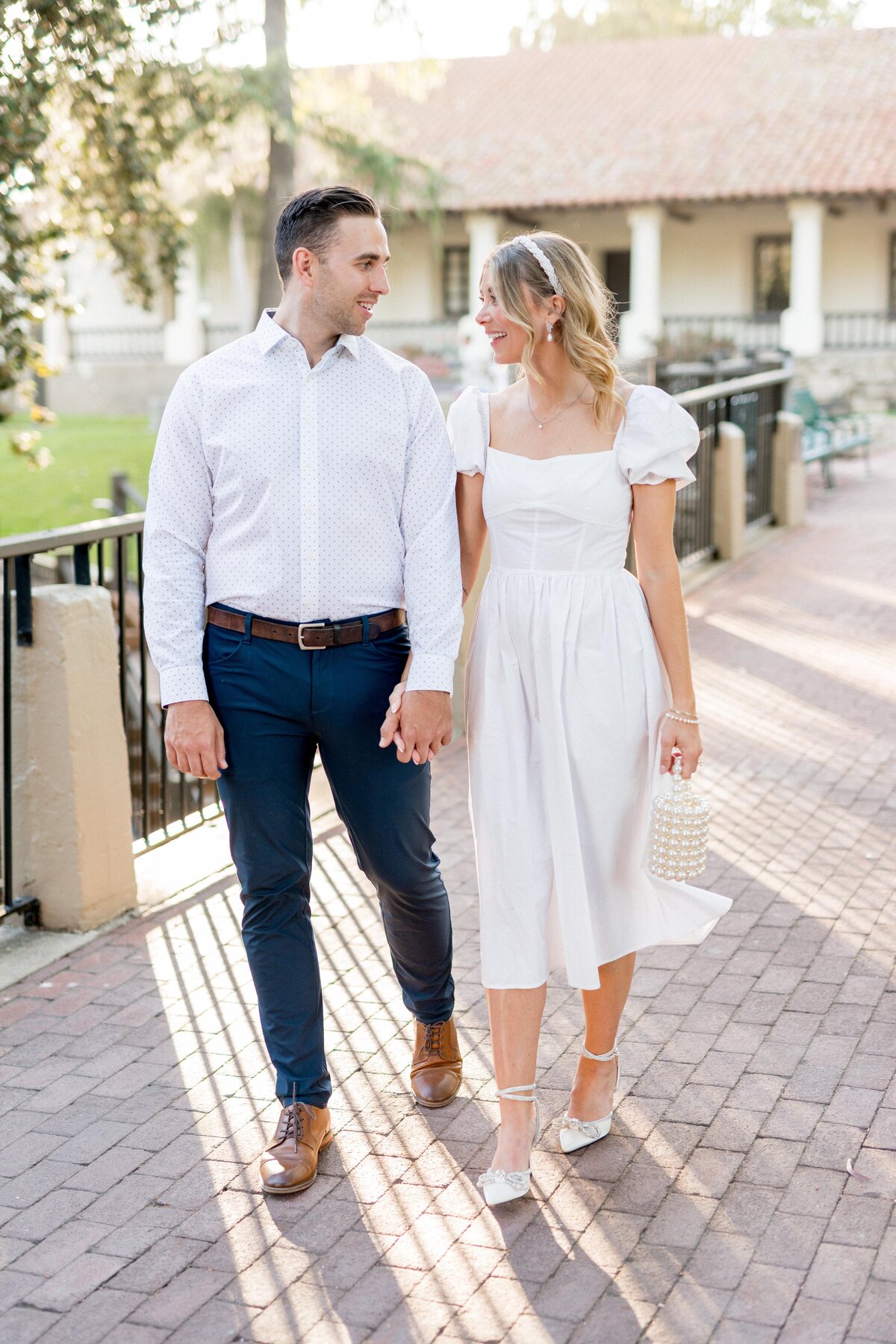 Engaged couple strolling hand in hand in downtown San Luis Obispo—romantic, stylish, and full of California charm.