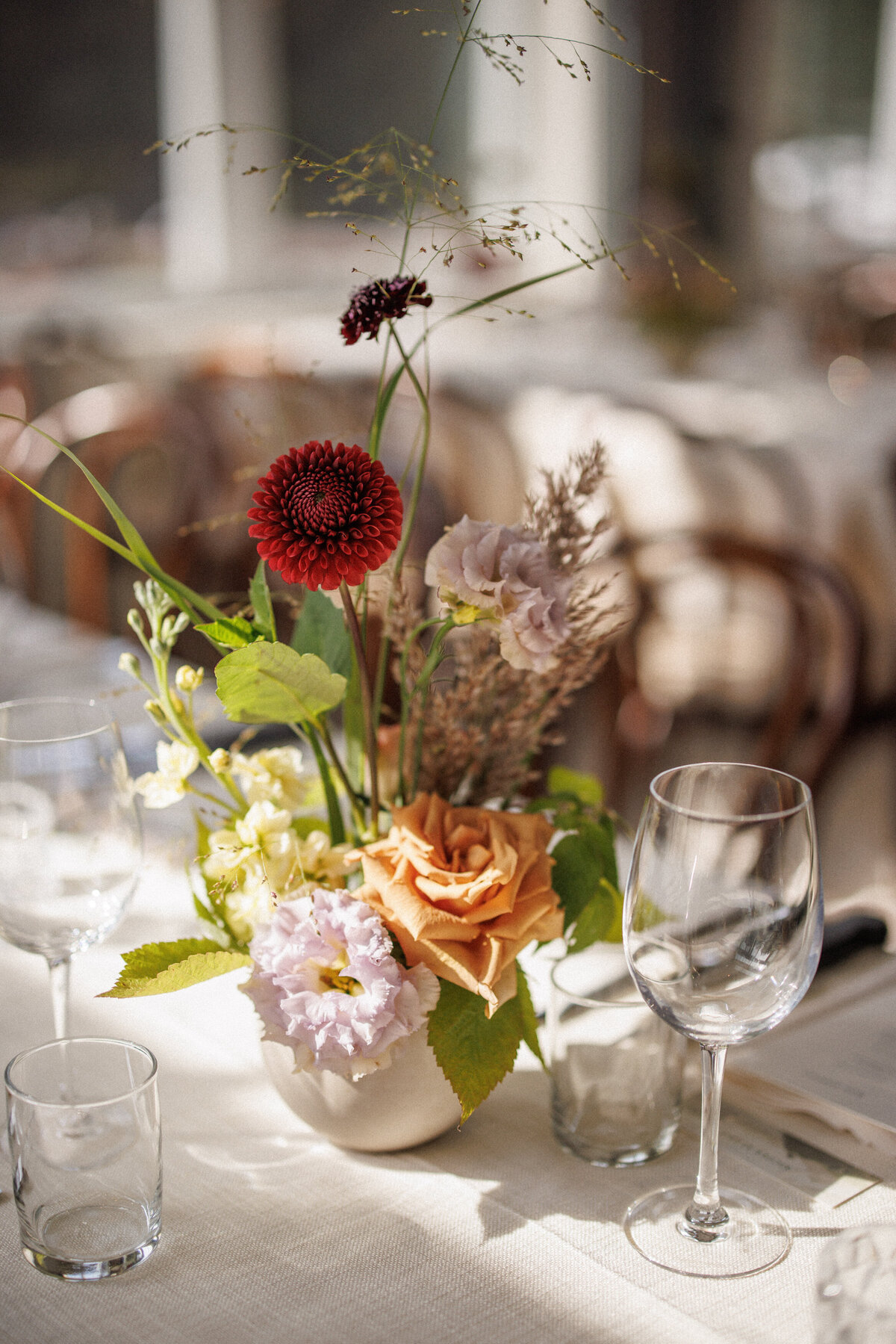A simple garden centrepiece features bright flowers at a wedding reception in Montreal. 