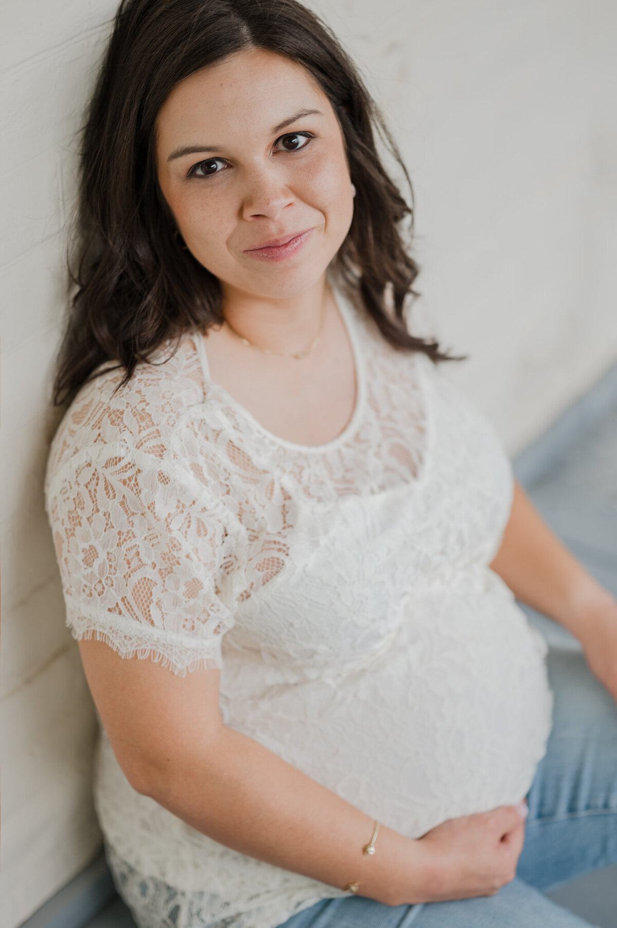 Portrait of an expecting woman in a lace shirt.