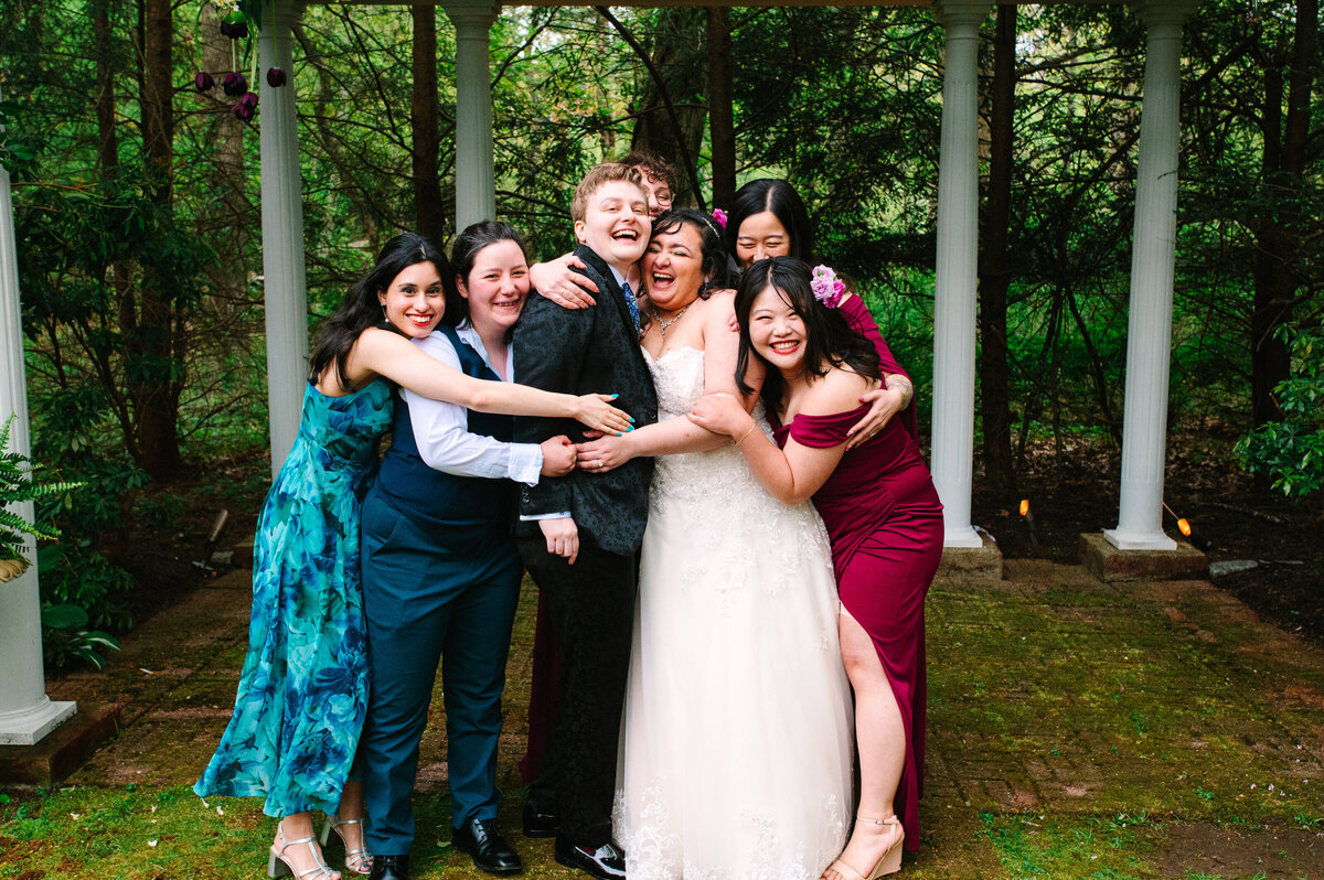 Brides and bridal party hugging