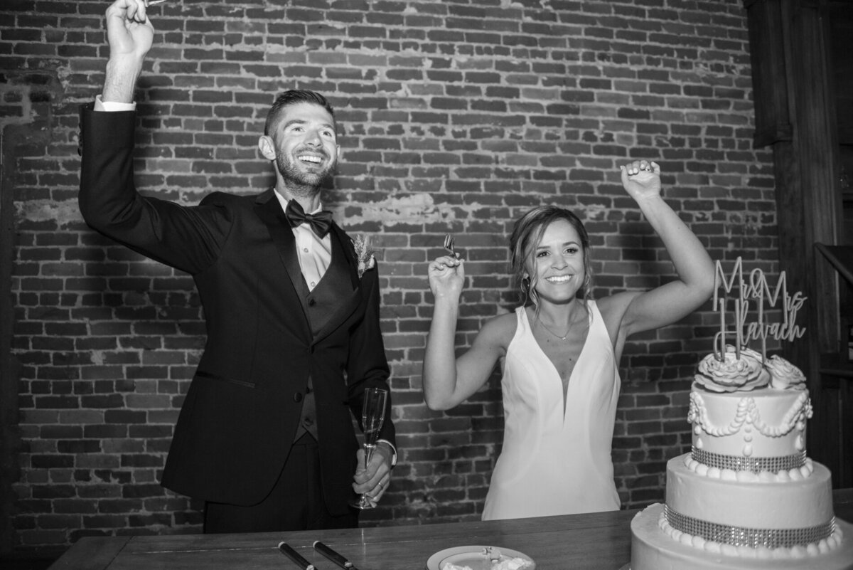 Couple celebrating and cutting wedding cake at Century Room on the Park Asheville