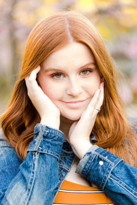 Senior girl with red hair with head in hands