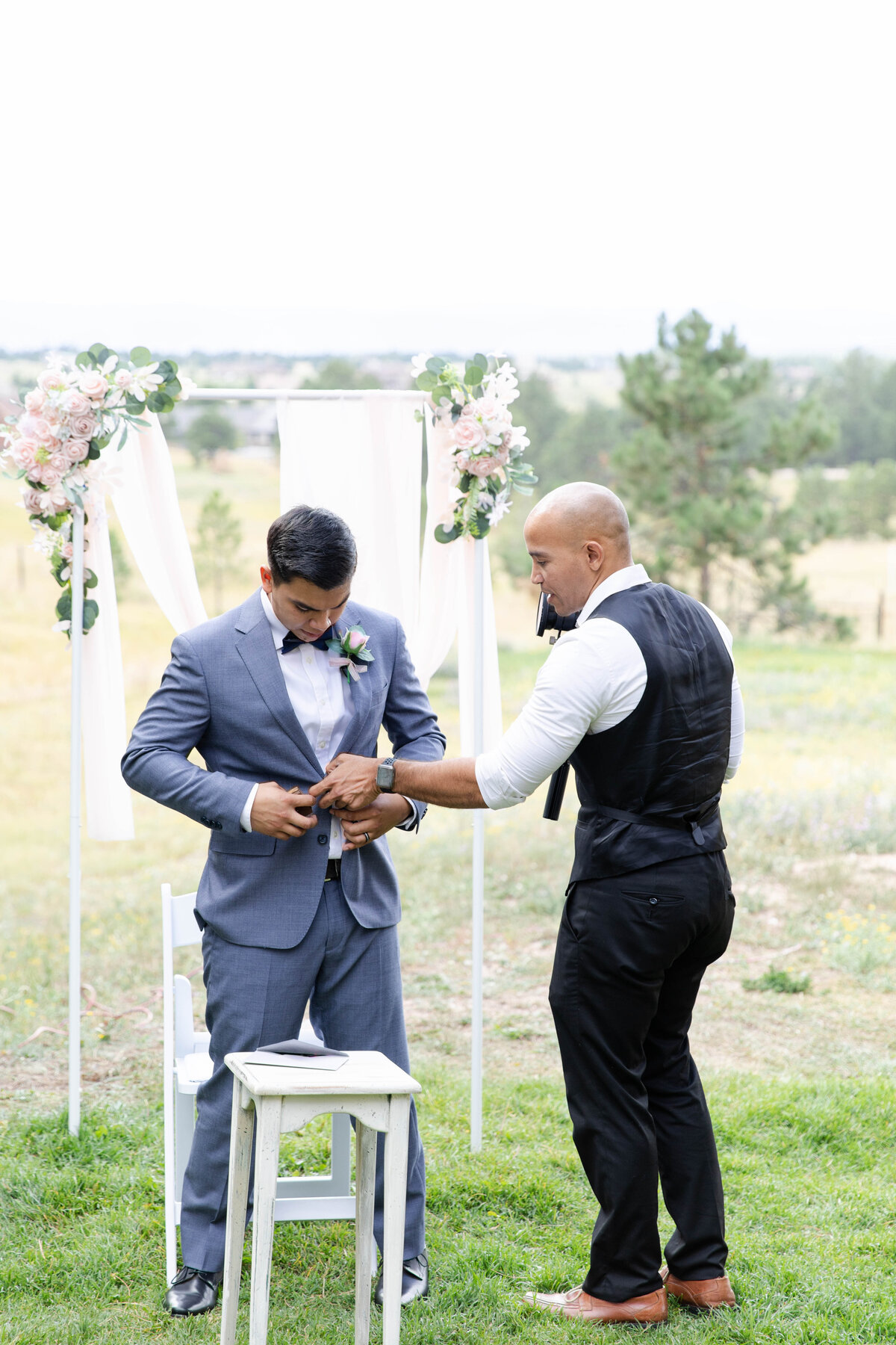 wedding videographer ariel helps groom tidy up his coat