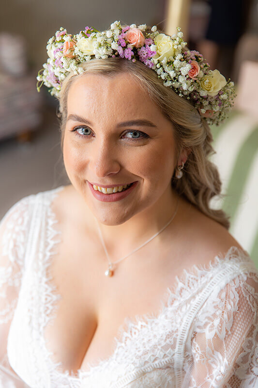 Bride wearing her delicate wedding crown by the  little flower hut