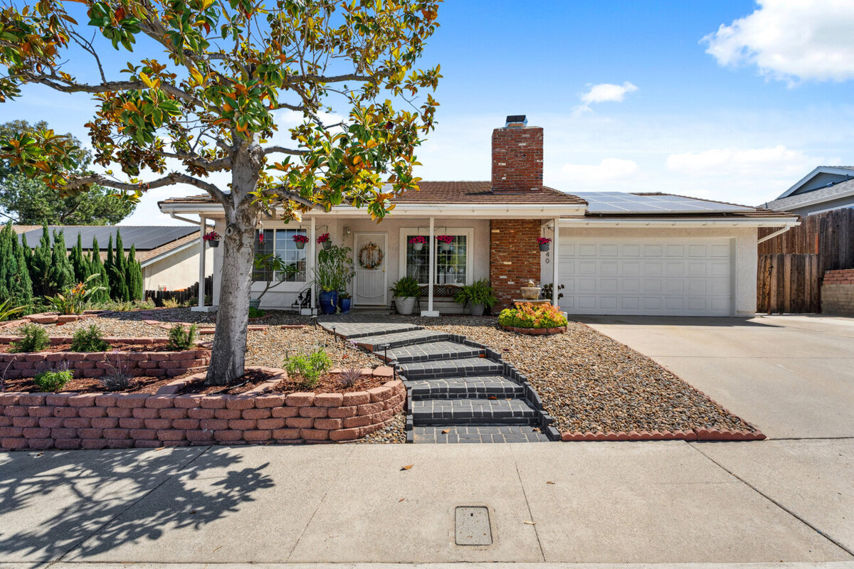 Front of home in Escondido, Ca. White home with gravel and brick walkway. 