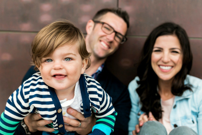 Portrait of baby in focus with parents in the back