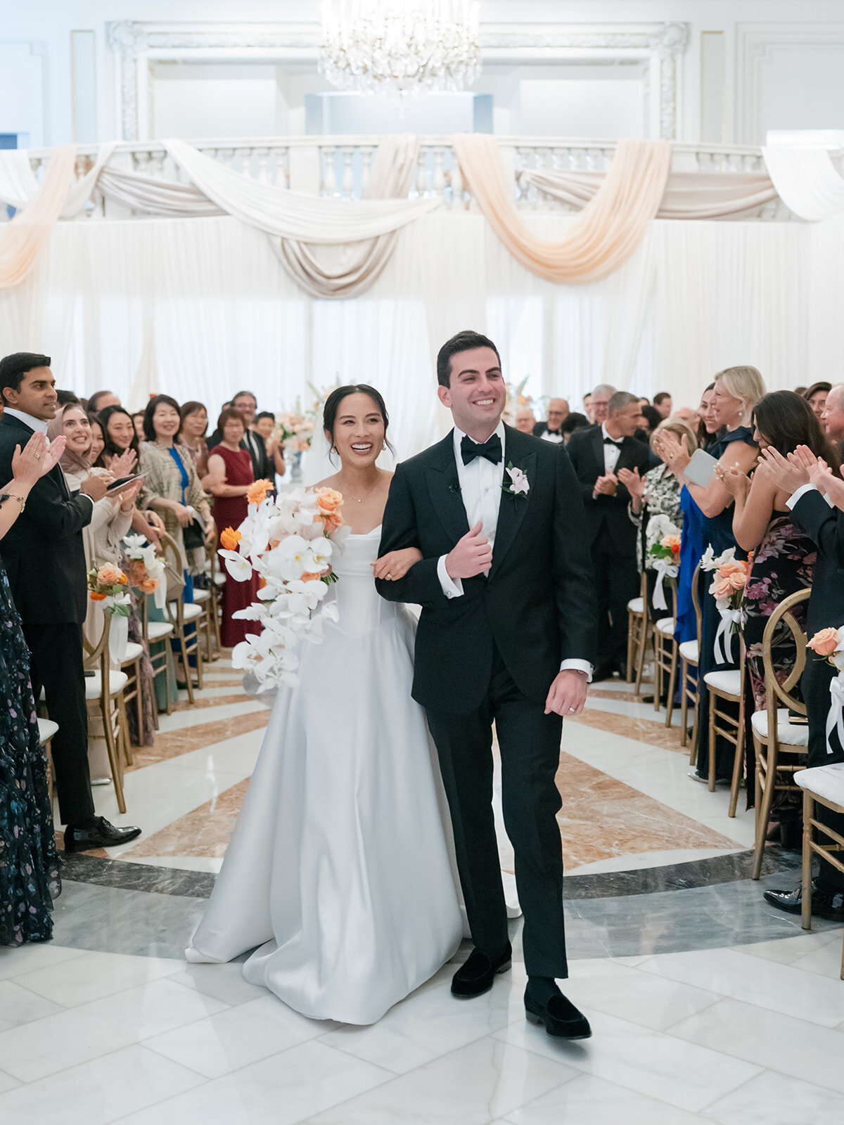 Clients recessing down the aisle after their ceremony on the National Museum of Women in the Arts. 