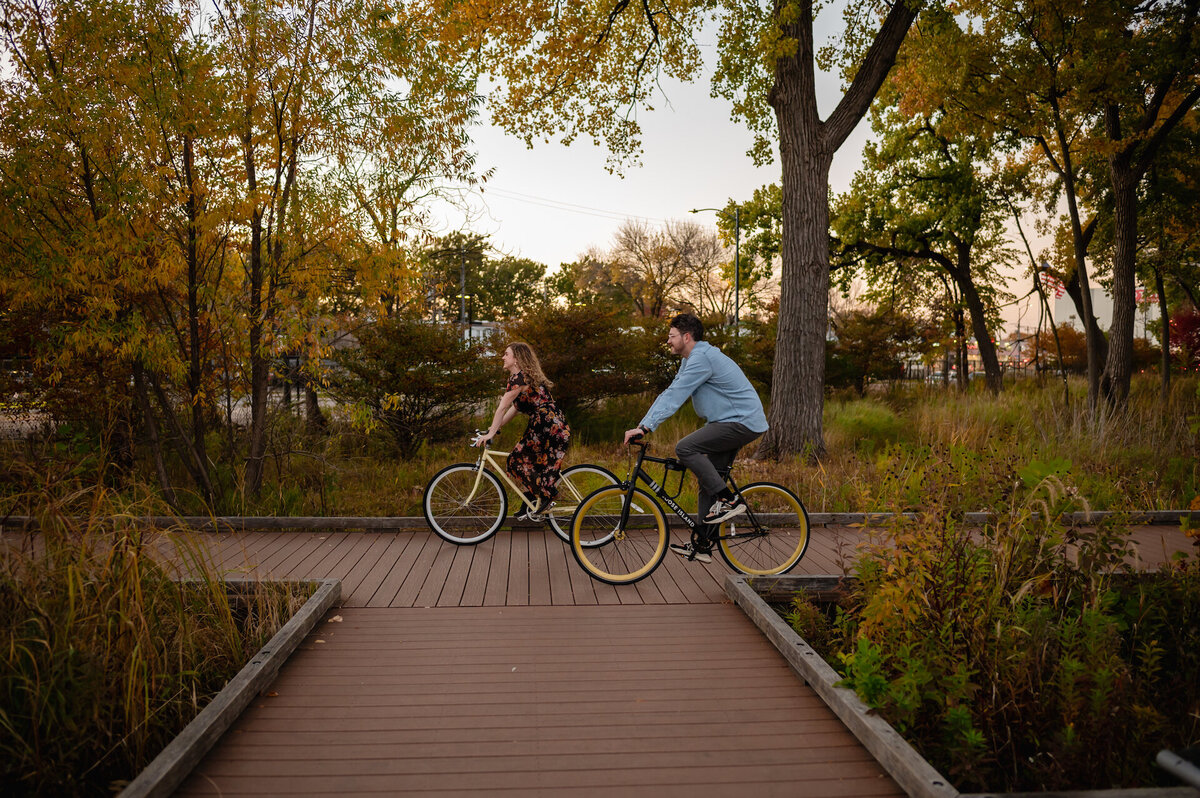 A couple rides biked together in a park