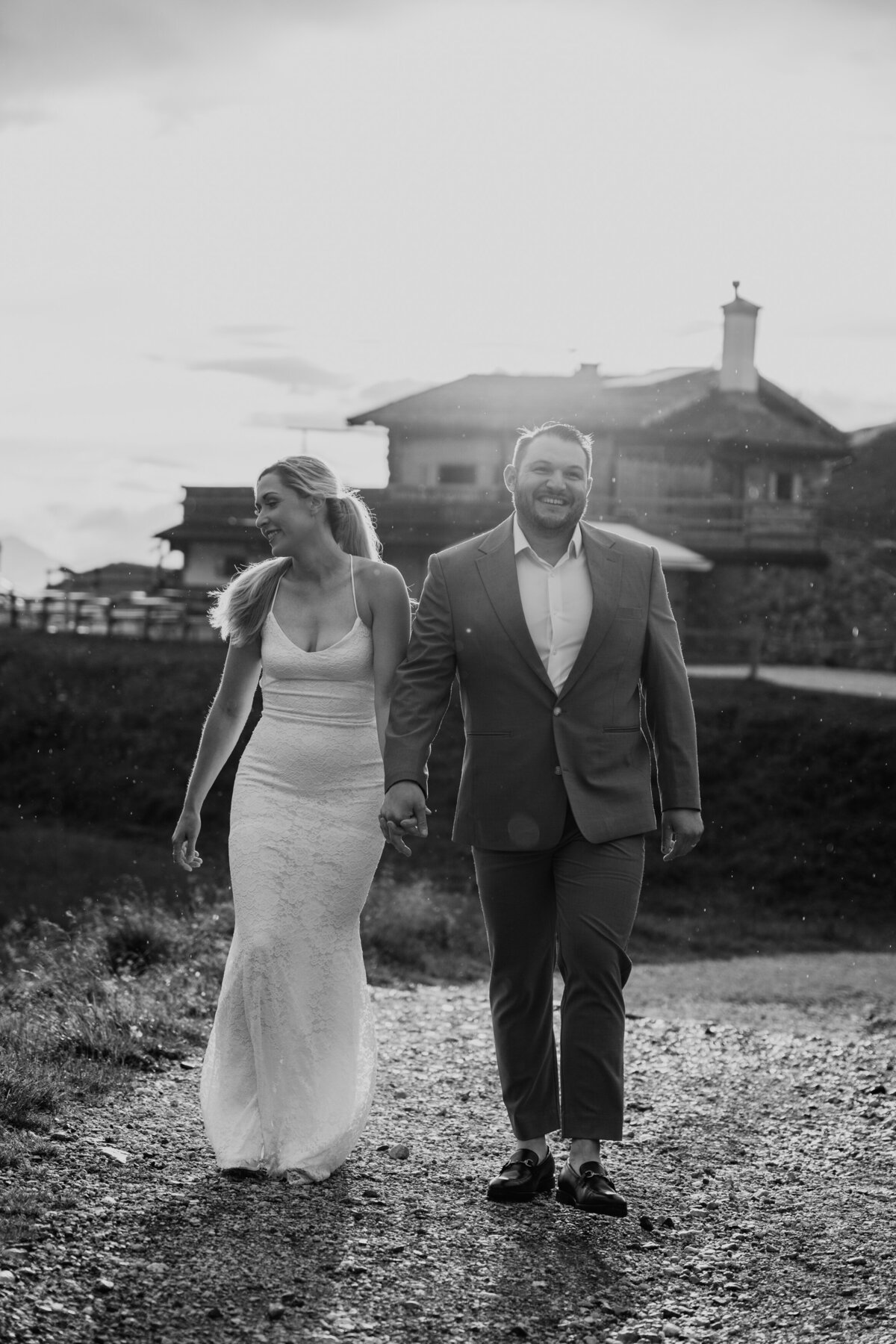 Black and white photo of couple walking toward mountain hut