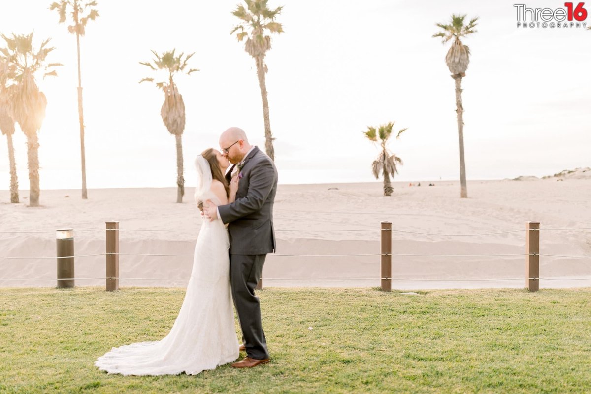 Wedding couple share a kiss along the coast