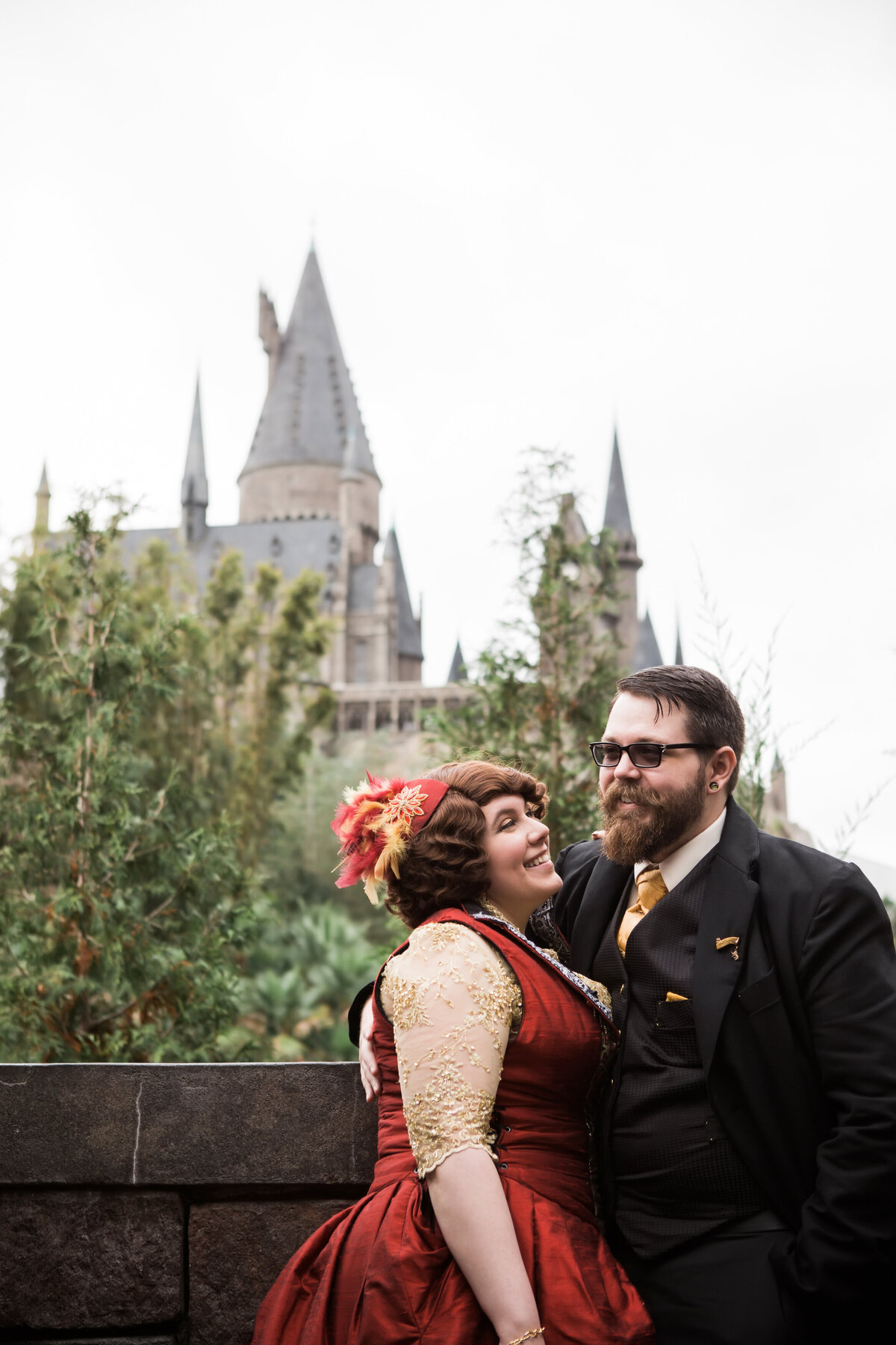 Fantasy wizarding inspired wedding couple in front of a castle.