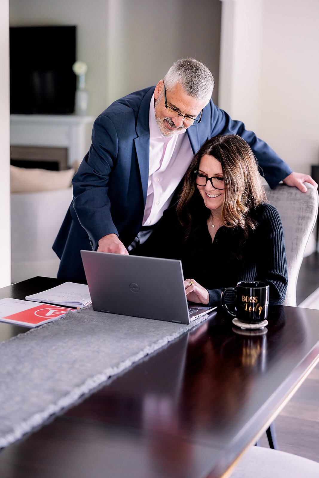 Owners of Arciera Home Care looking at a computer screen at a table with coffee mug