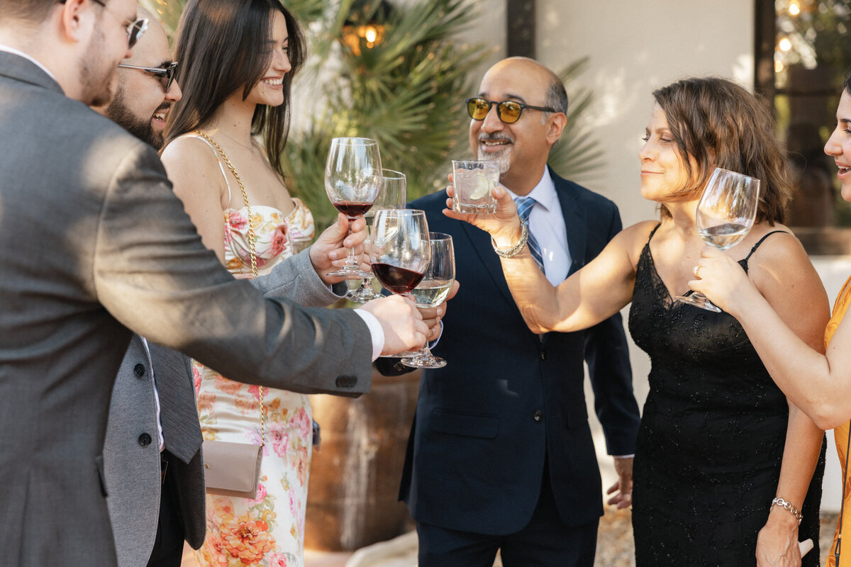 Candid moment of guests toasting at cocktail hour at El Chorro in Paradise Valley, Arizona