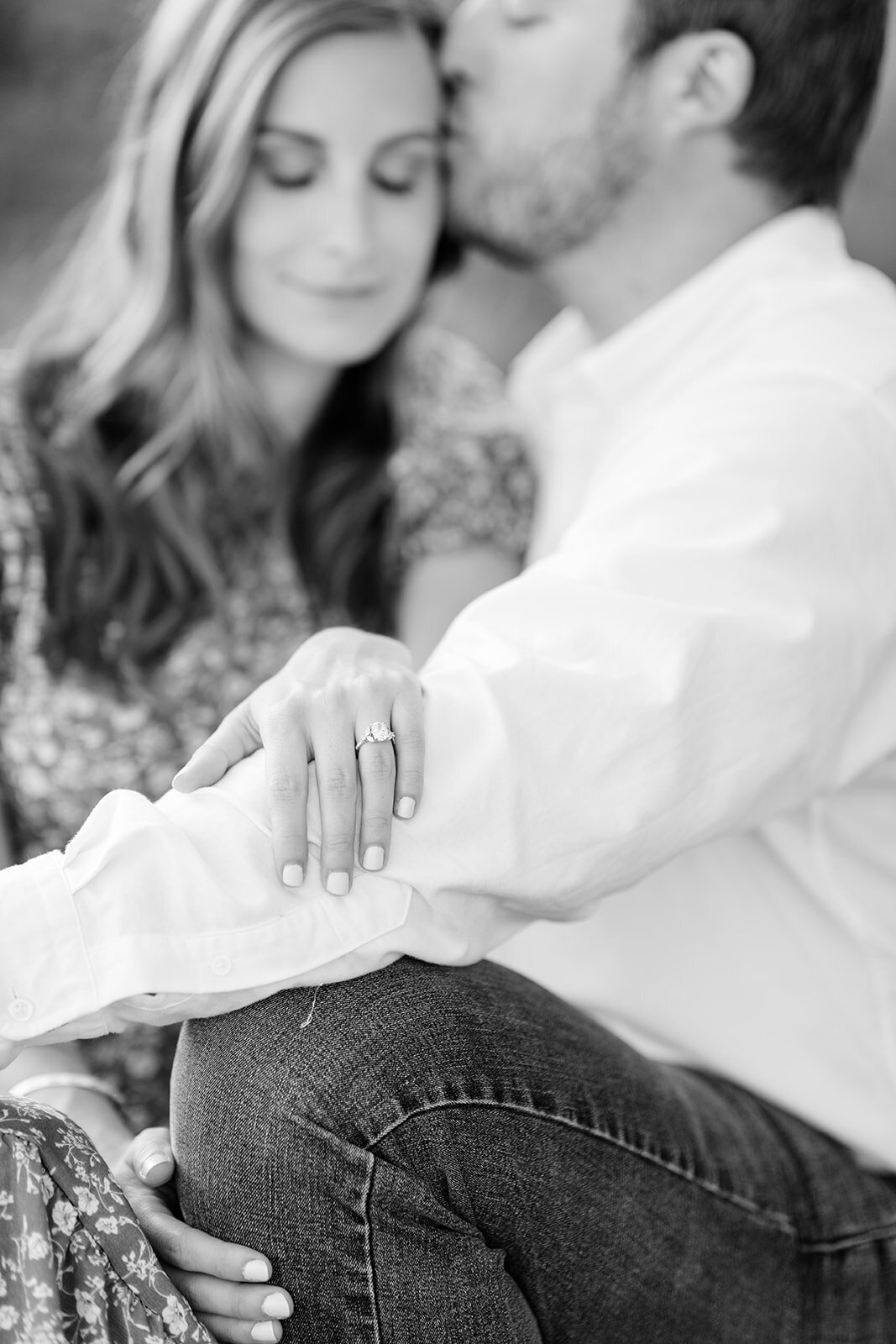 Engagement photo of couple sitting in black and white