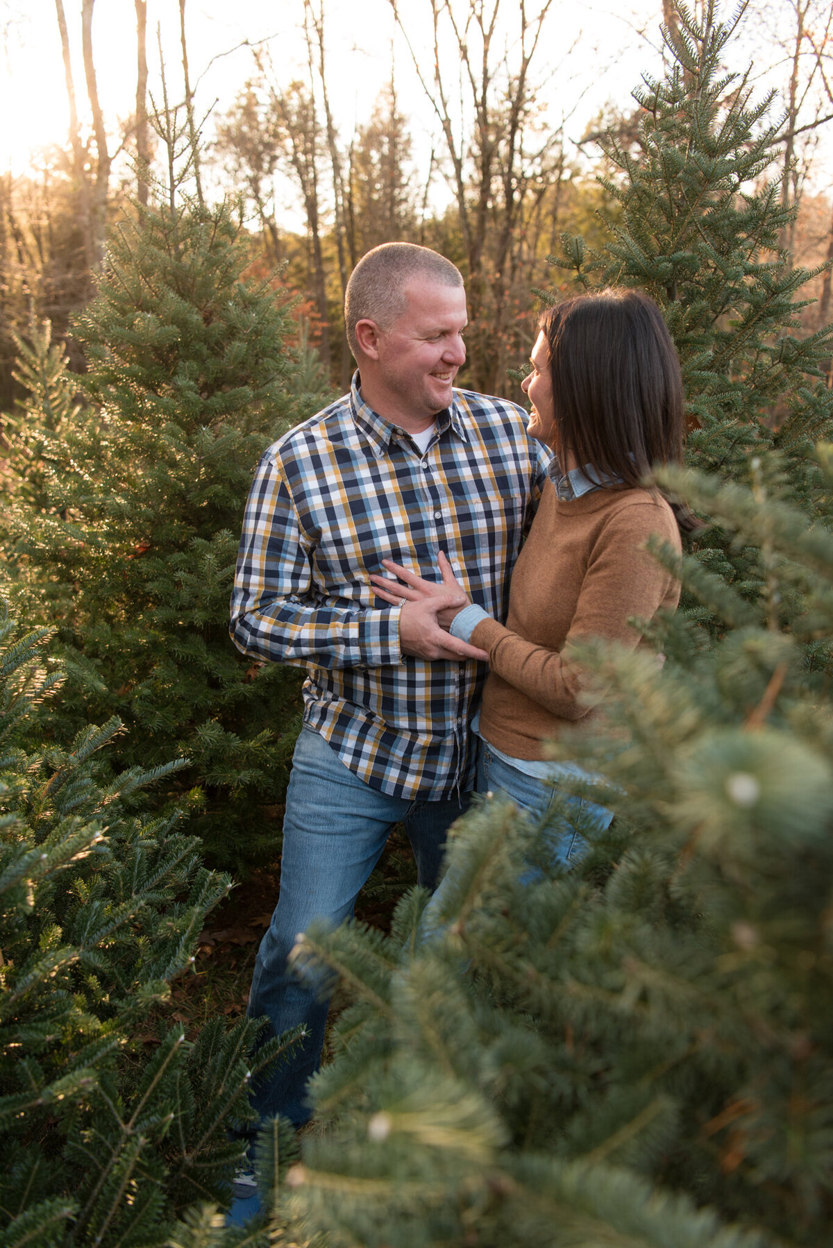 Husband and wife looking at each other at tree farm