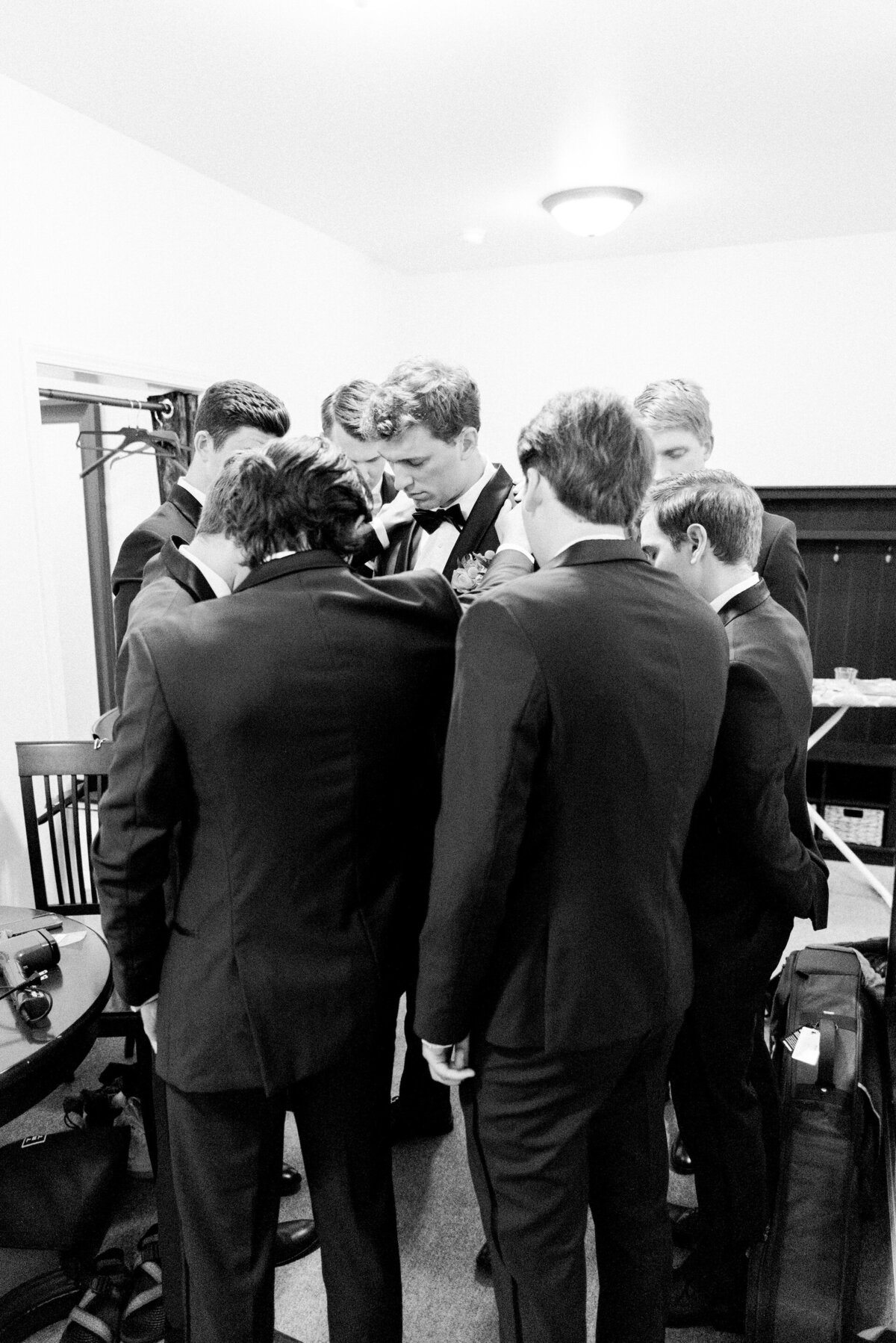 a groom praying with his groomsmen before his wedding