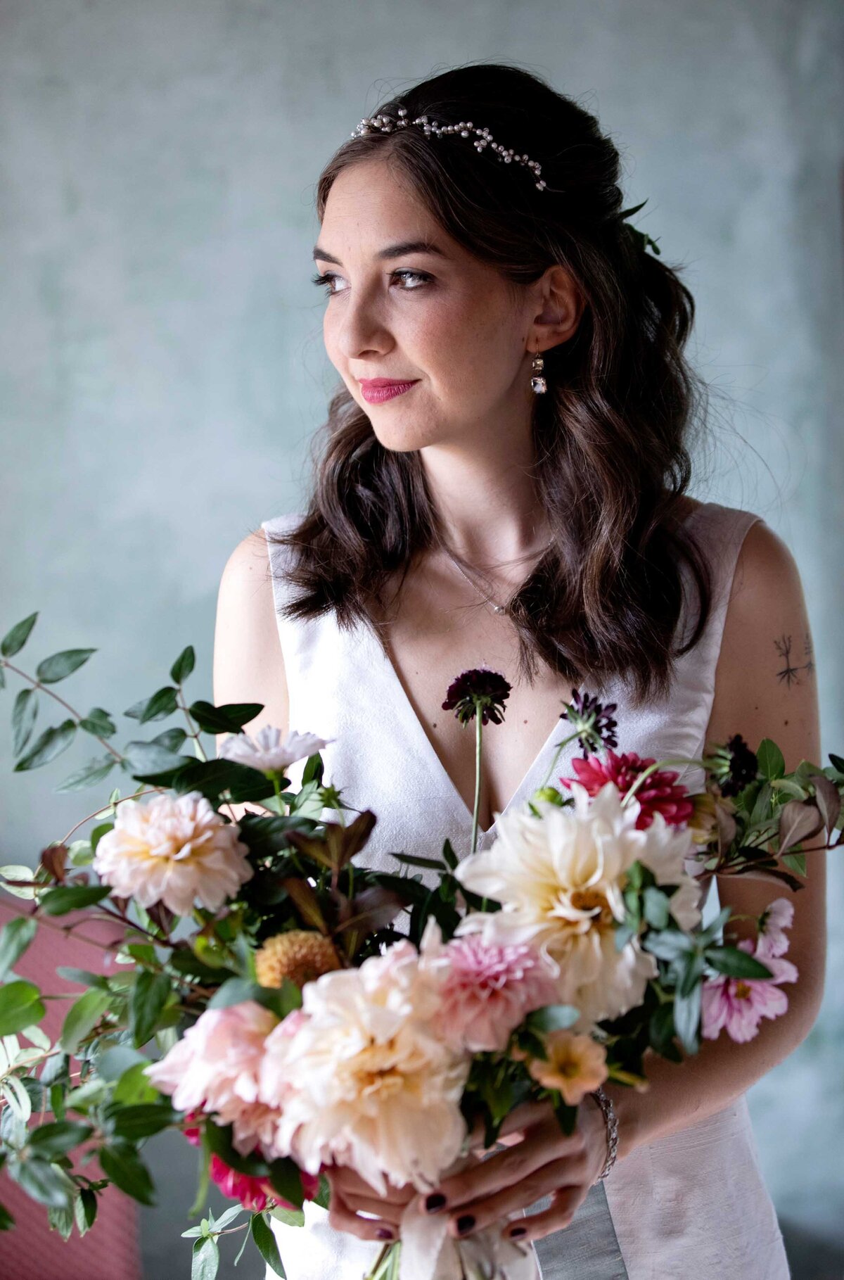 bride with small tattoo, holding her bridal bouquet