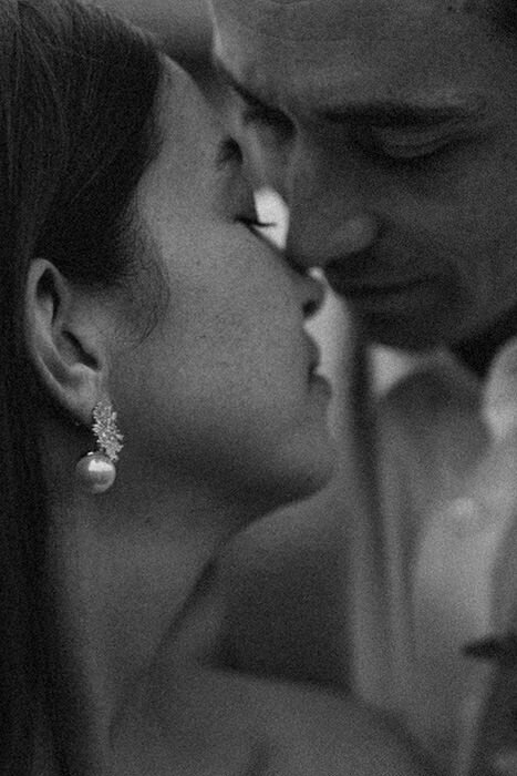 Plan rapproché d'un couple de mariés sur le point de s'embrasser. Moment intime capturé en noir et blanc. 