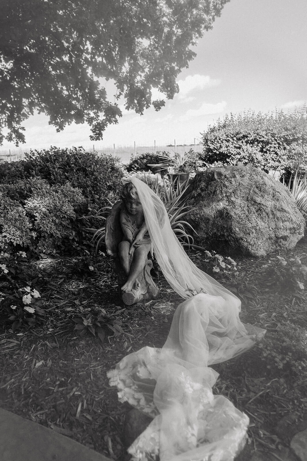 Cherub angel statue with wedding veil draped over it