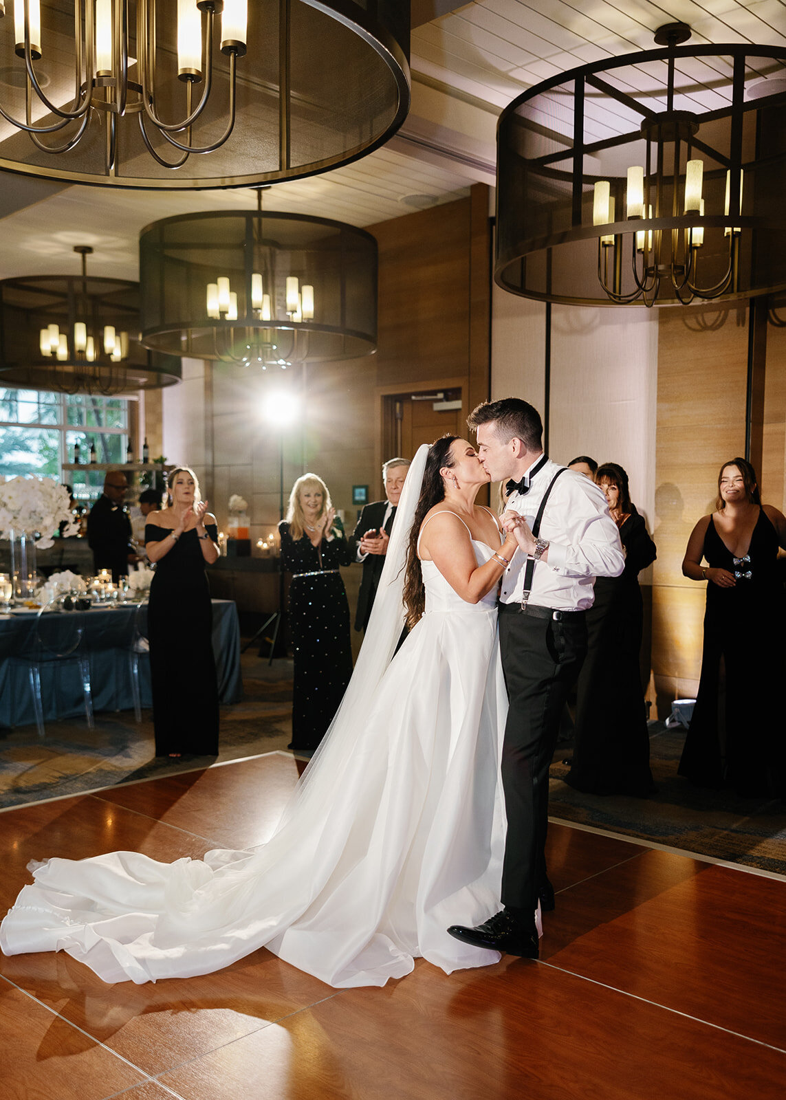 The bride and groom share a romantic kiss on the dance floor surrounded by their wedding guests during their Miami reception, photographed by Claudia Amalia Photography.