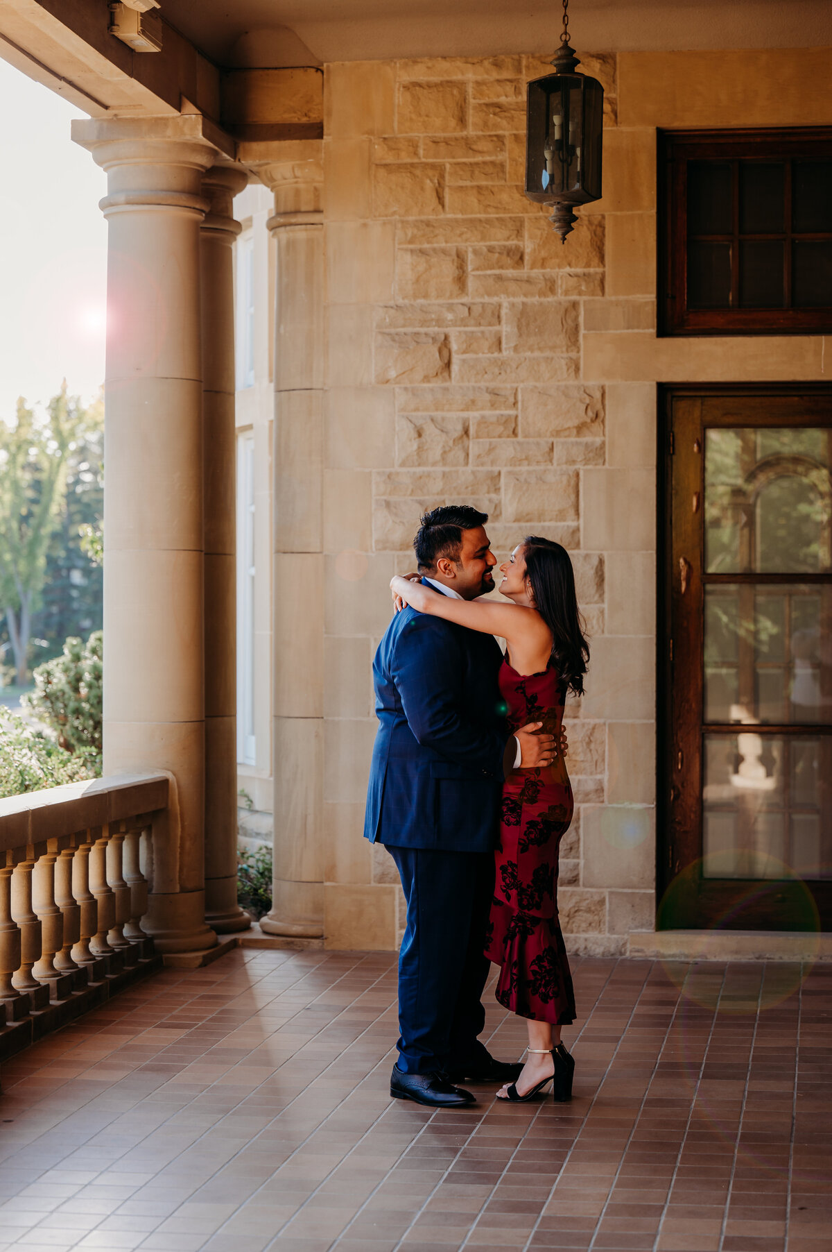 couple kisses on the front porch of historical building
