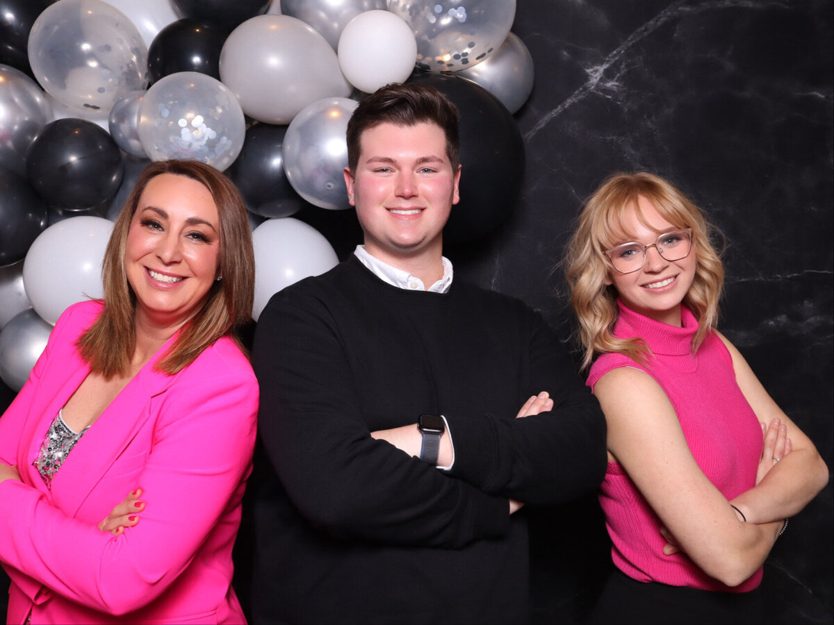 group of three people cross their arms and smile for the adair glam photo booth