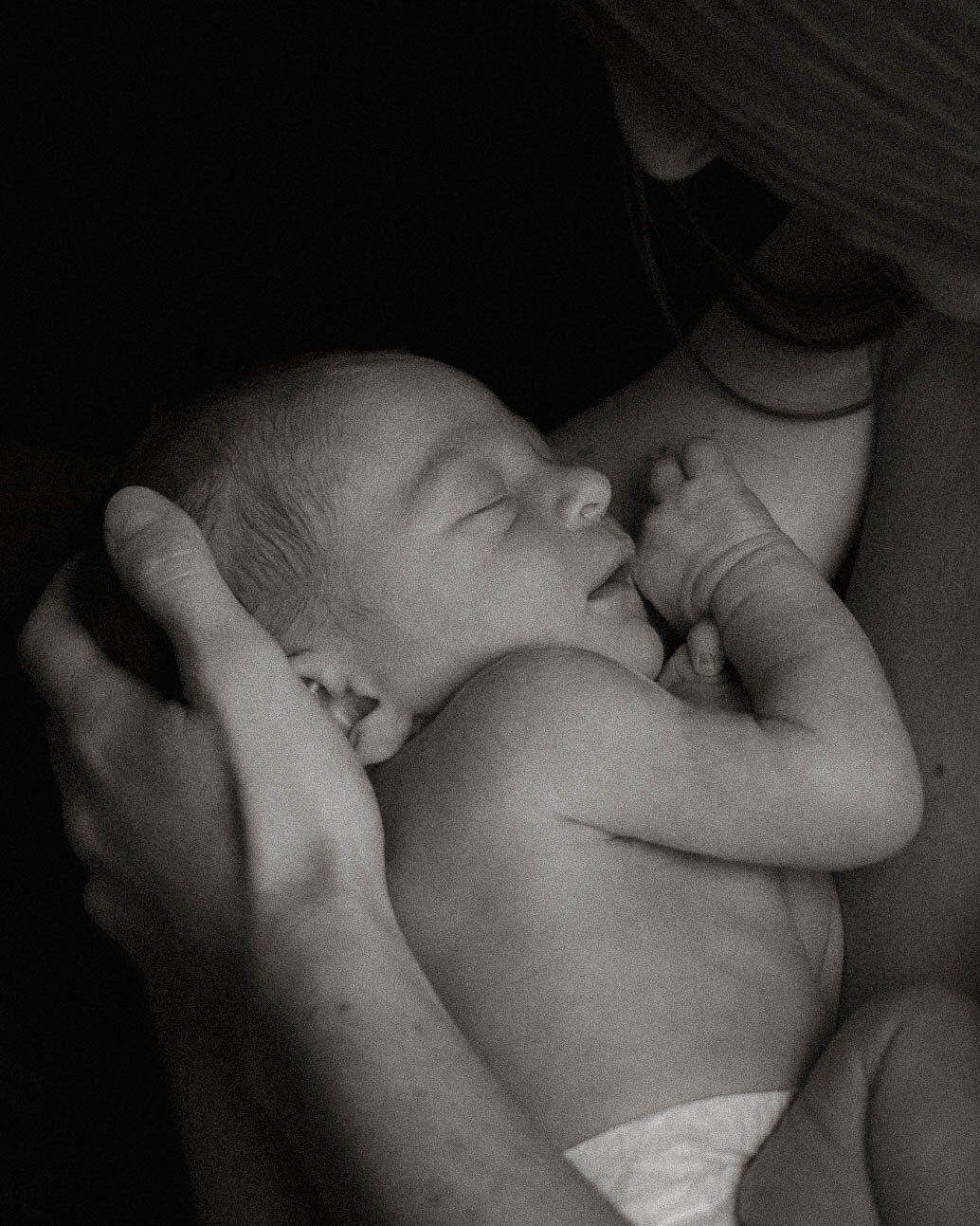 Skin to skin baby portrait sleeping on mom's chest during a newborn session.