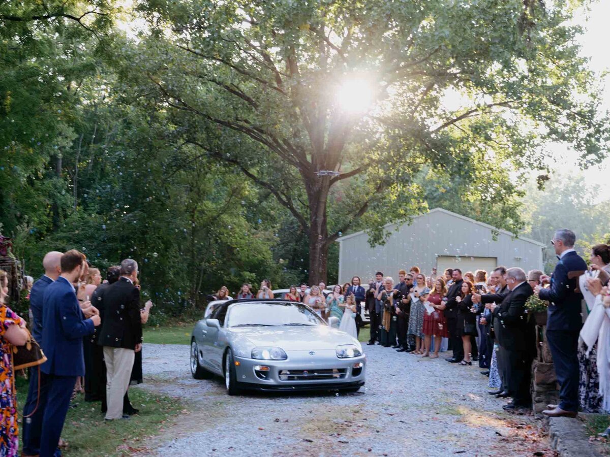 Couple's ceremony exit in a sports car.