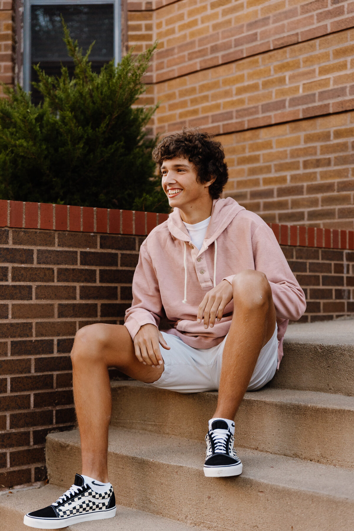 A boy sitting on a small staircase smiling