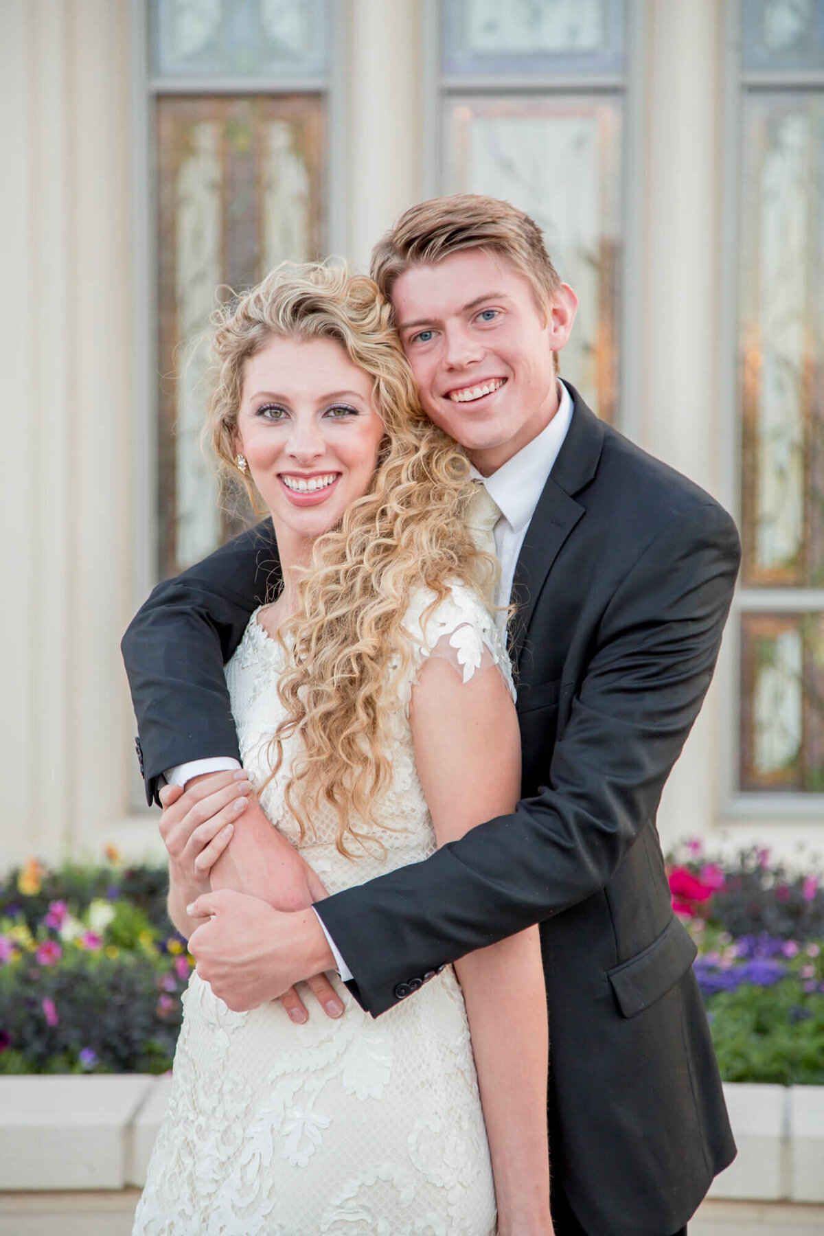 a wedding couple hugging and posing